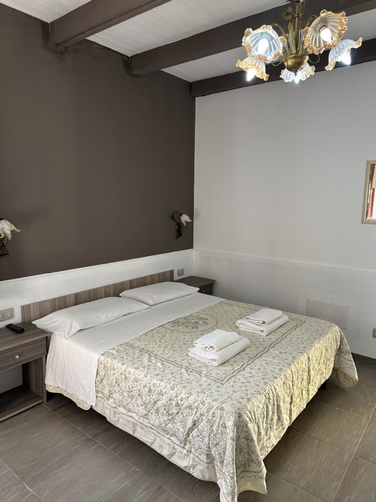 Camera con parete scura e letto rifatto